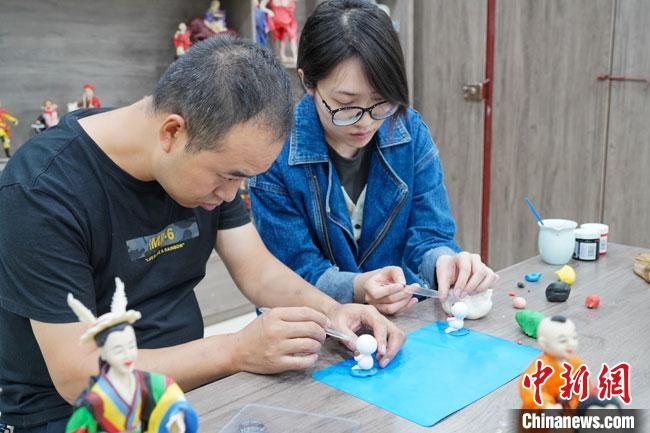<a target='_blank'  data-cke-saved- >中新社</a>記者(右)現(xiàn)場(chǎng)體驗(yàn)面塑制作過(guò)程?！￡悹?zhēng)強(qiáng) 攝