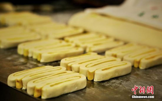 圖為面劑被涂上胡麻油，切成條狀用作月餅的花型制作。張文 攝