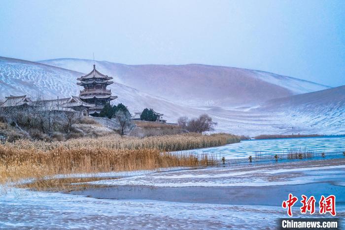 2021年11月28日，雪落鳴沙山月牙泉景區(qū)?！⊥醣筱y 攝