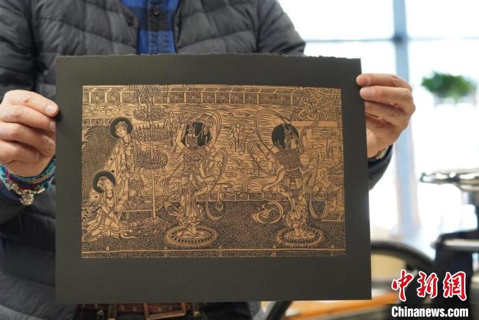 圖為手工書藝人展示敦煌雕版壁畫印刷品?！【琶赖┰?　攝