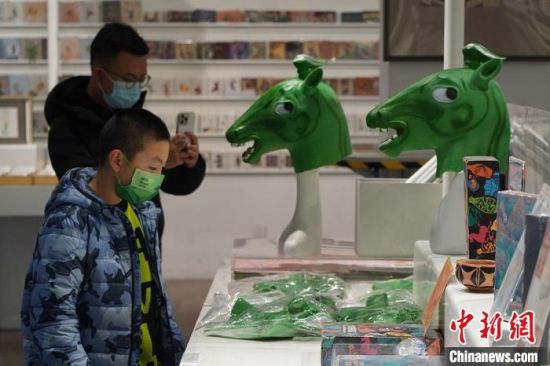 圖為“神馬來了”銅奔馬頭套吸引參觀者駐足。　九美旦增 攝