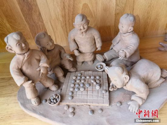 圖為泥塑作品展現(xiàn)下棋場(chǎng)景。 劉玉桃 攝