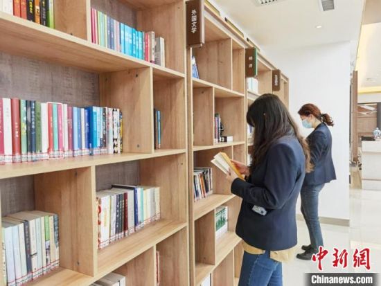 圖為在甘肅公航旅建設(shè)集團(tuán)有限公司的職工書屋，職工挑選書籍?！⌒煅?攝