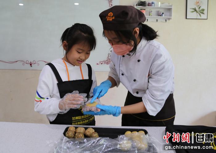 圖為在甘臺胞小朋友在工作人員指導(dǎo)下制作月餅。九美旦增 攝