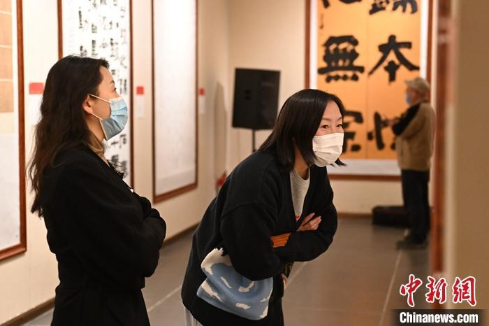 圖為甘肅蘭州，參展書(shū)法作品吸引參觀者。 中新社記者 李亞龍 攝