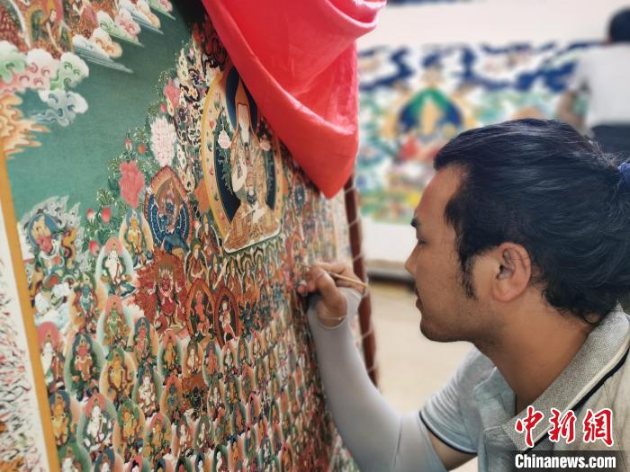 圖為更登才讓的徒弟繪畫唐卡。　張?zhí)砀?攝