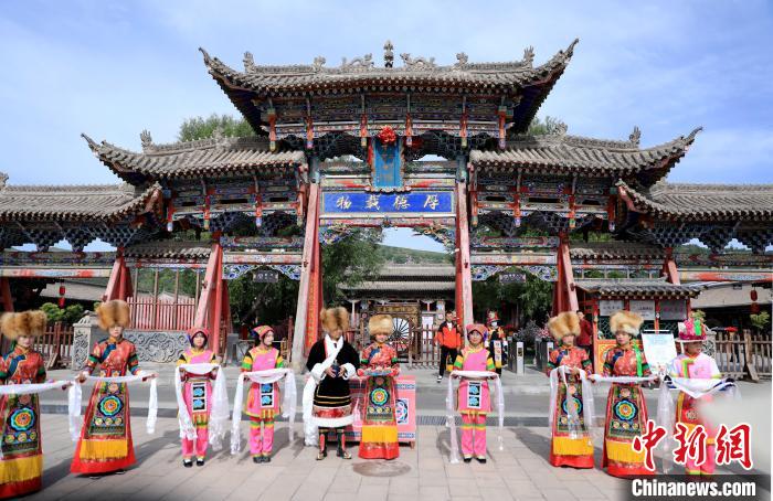 圖為身穿土族服飾的工作人員迎接訪客?！⊙Φ?攝