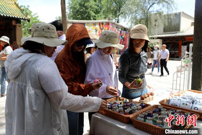 圖為民眾挑選手工藝產(chǎn)品?！⊙Φ?攝