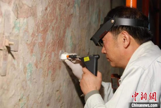 敦煌研究院研究員樊再軒進行壁畫修復。(資料圖)張云文 攝