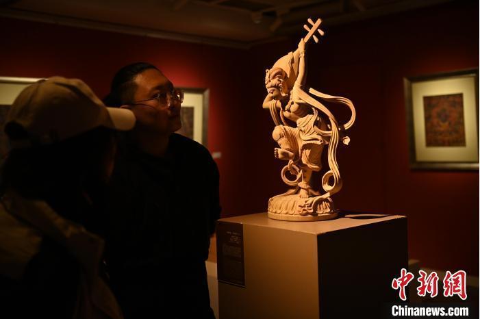 圖為季茂杰向參觀者介紹自己創(chuàng)作敦煌木雕的過程。李亞龍 攝</p>
<p>