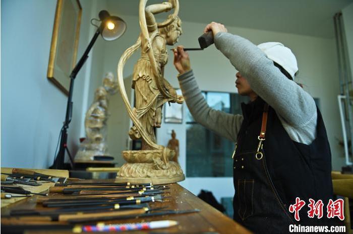 圖為季茂杰進行敦煌元素的木雕創(chuàng)作。李亞龍 攝</p>
<p>