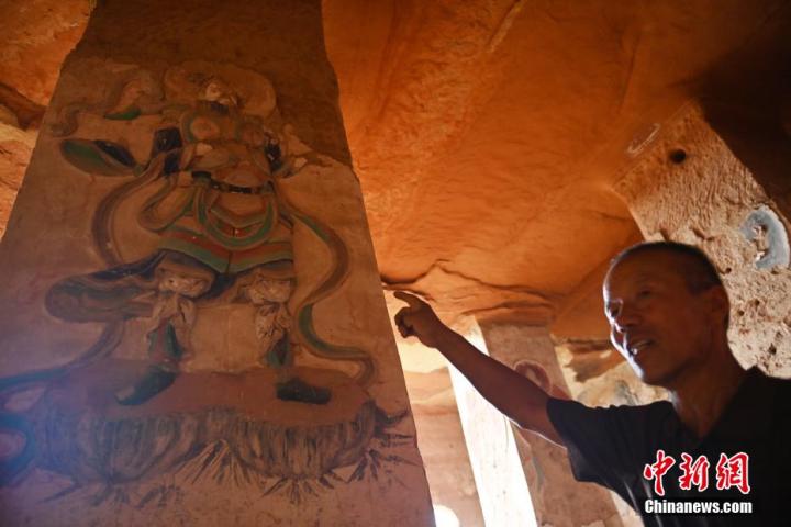7月15日，甘肅省平?jīng)鍪袥艽h百里石窟長廊羅漢洞石窟內(nèi)，該窟文保員郭建平介紹窟內(nèi)石刻彩繪壁畫。郭建平家中三代人曾自發(fā)保護(hù)羅漢洞石窟。羅漢洞石窟遺存40余個窟龕，以北魏至清代風(fēng)格為主。中新社記者 李亞龍 攝</p>
<p>