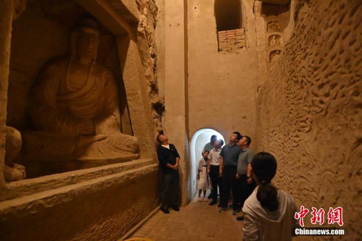 7月15日，游人參觀甘肅省平?jīng)鍪袥艽h百里石窟長廊中的王母宮石窟。百里石窟長廊位于涇川縣境內(nèi)，由512個石窟、5眼窟中石井組成，現(xiàn)存王母宮石窟、鳳凰山石窟、南石窟寺、丈八寺石窟、羅漢洞石窟、太山寺石窟等規(guī)模較大的石窟群，還有數(shù)量眾多的小石窟群。王母宮石窟又名千佛洞，該窟設(shè)計宏大，造像生動，窟內(nèi)擁有造像數(shù)百尊，是較為珍貴的佛教文化歷史遺存。中新社記者 李亞龍 攝</p>
<p>