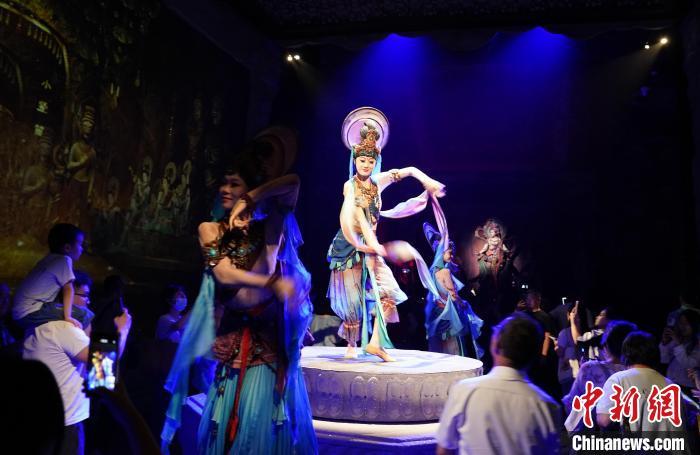 《樂動敦煌》是全球首部洞窟式沉浸體驗劇，利用真人與數(shù)字影像虛實交換實現(xiàn)沉浸式體驗。圖為2023年8月28日晚，《樂動敦煌》演出。(資料圖)中新社記者 毛建軍 攝